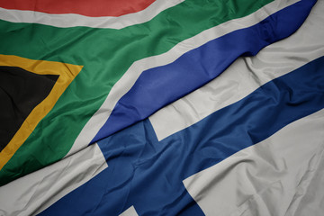 waving colorful flag of finland and national flag of south africa.