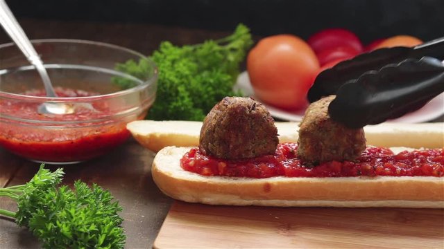 put vegan lentil  meatballs on loaf bread with tomato sauce make sandwich