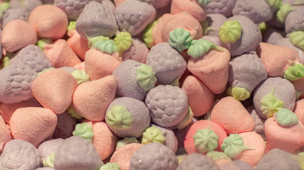 Airy marshmallows in the shape of a pink purple strawberry, close-up background wallpaper. Sweet candy marmalade. A large pile of fruit berry sweets with sugar