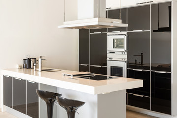 Modern white and black kitchen detail with island and stools