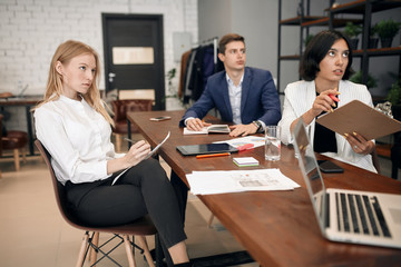 young serious ambitious business people listening to their boss. performance in the office with modern interior. closeup photo