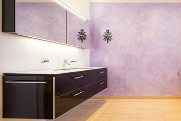 Bathroom with modern black sink and lilac wall