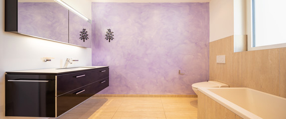 Bathroom with modern black sink and lilac wall