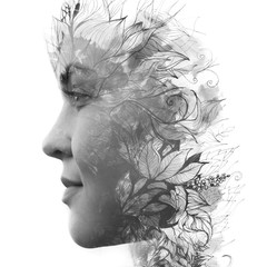 Paintography. Double exposure profile of a young natural beauty, with face and hair combined with hand drawn leaves dissolving into the background, black and white