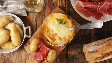 mont d'or, traditional french dish- cheese fondue with bacon, salami and potato