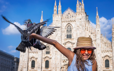 Doves eats feed from the child's hand and the child is afraid