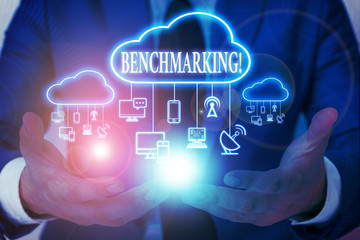 Word writing text Benchmarking. Business photo showcasing evaluate something by comparison with standard or scores Male human wear formal work suit presenting presentation using smart device