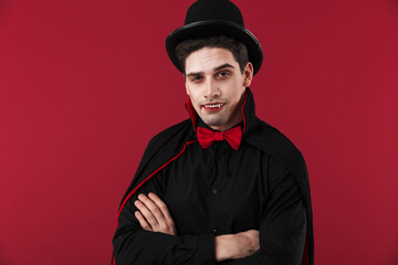 Image of vampire man with blood and fangs in black halloween costume