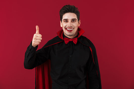 Image of vampire man with fangs in halloween costume showing thumb up