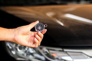 A man holding compass on black car background, journey of life concept