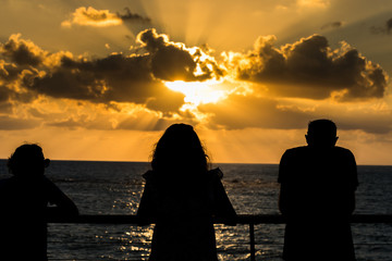 Beautiful sunset and golden twilight, and clouds, Silhouettes of people standing on the coast of...