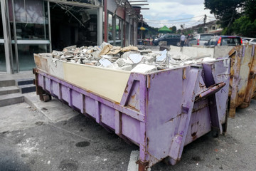 Fototapeta premium Dumpster full load with construction site background
