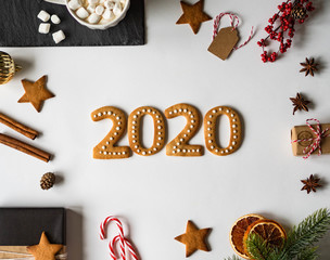 Gingerbread of the form of a numbers. 2020 new year ginger cookies and mug cacao with marshmallows and New Year's attributes on white background. Top view.