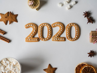 Gingerbread of the form of numbers. 2020 new year ginger cookies and mug cacao with marshmallows on white background and Seasonal New Year's attributes . Top view.