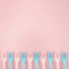 Colorful plastic forks arrangement on pink background