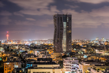Obraz premium Night aerial view of Tel Aviv City with modern skylines and luxury hotels at the beach near the Tel Aviv port in Israel.