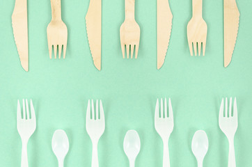 Colorful disposable cutlery on turquoise background