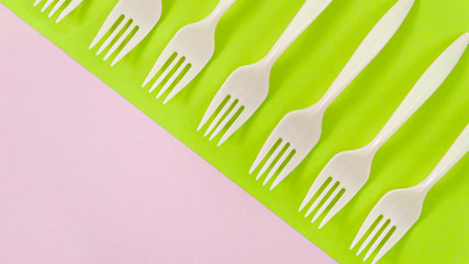 White plastic forks on colorful background