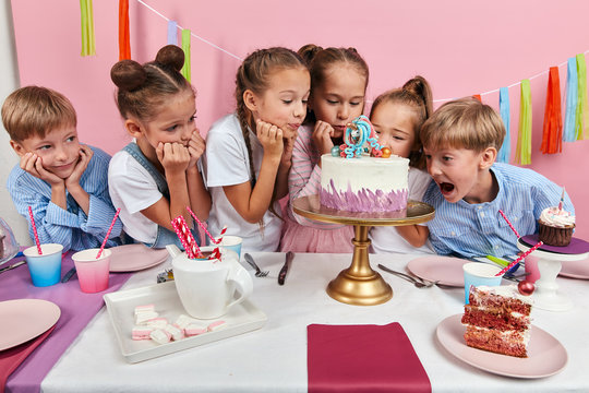 little children being afraid of breaking any detail of cake. close up photo.
