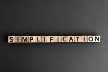 Simplification - word from wooden blocks with letters, Simplified simplification concept,  top view...