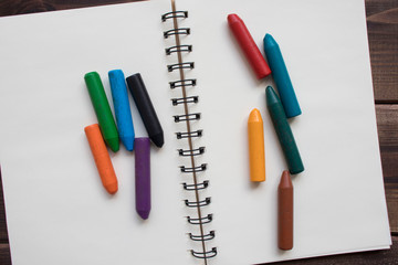 Back to school background with colored pencils on a Notepad, top view, copy space