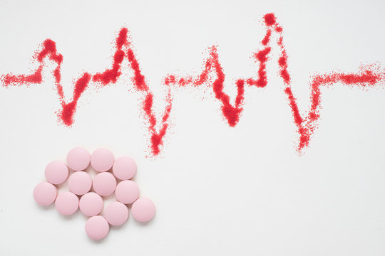 concept of medical care, heart rate, cardiograms, ECG and pills - Powered by Adobe