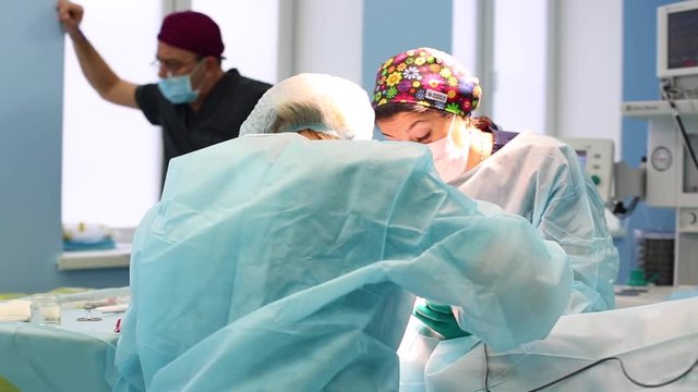 A team of surgeons has a major plan during surgery, a blue light operating room, a rhinoplasty operation to improve the aesthetics of the nose. Medetsina, plastic surgery.