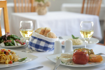 Beautifully decorated meals and glasses of white wine on the wooden table	