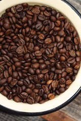 Roasted brown coffee beans in a bowl