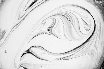 Abstract background, top view of white and black swirled paint texture. 