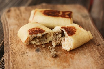 Pancakes with meat on a wooden table 