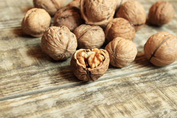  Walnuts close-up on a wooden background. One nut is chopped.