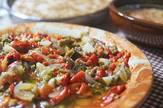 Typical Catalan escalibada dish with fresh vegetables in a rustic kitchen in Catalonia. Home made cuisine and gastronomy travel concept with empty copy space for Editor's text.