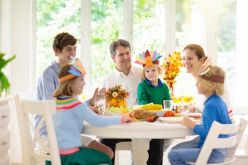 Family with kids at Thanksgiving dinner. Turkey.