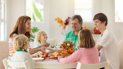 Family with kids at Thanksgiving dinner. Turkey.