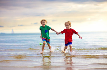 Kids play on tropical beach. Sand and water toy.