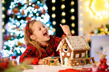 Kids baking gingerbread house. Christmas at home.