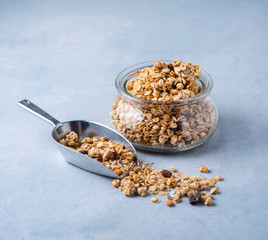Homemade  granola with nuts  in a glass jar on blue  background.Healthy vegan food