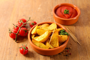 grilled potato with tomato sauce on wood background