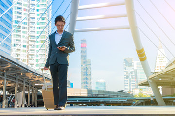 Fototapeta premium Business man walking with suitcase in city.