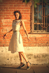 georgeous woman in white dress dancing in the street