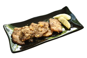 grilled slice pork with black pepper sauce topping fried chop garlic and cucumber on plate