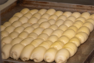 Fresh raw dough in product line. Cooks roll the dough for baking, pieces of raw dough on a metal board