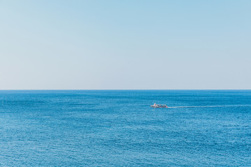 Boat on blue sea surface aerial view. Nature background
