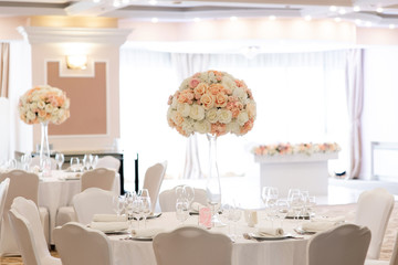 Flower decor on white round tables for a torched reception in the reception