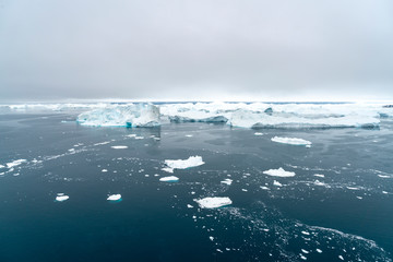 Arctic Icebergs Greenland in the arctic sea. You can easily see that iceberg is over the water surface  and below the water surface. Sometimes unbelievable that 90%25 of an iceberg is under water 