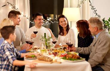 celebration, holidays and people concept - happy family having dinner party, drinking red wine and toasting at home