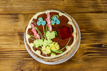 Kiev cake with cream, nuts and meringue on wooden table. Top view