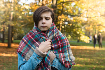 Przeziębiona dziewczyna w parku. Jesień. - obrazy, fototapety, plakaty