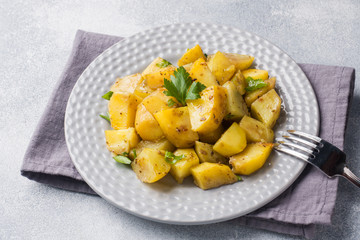 Baked potatoes with spices and herbs on a plate.